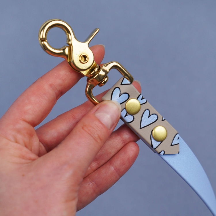 Złoty karabińczyk obrotowy smyczy miejskiej dla psa z Biothane – osłona z nadrukiem wzór Serca, zbliżenie detalu