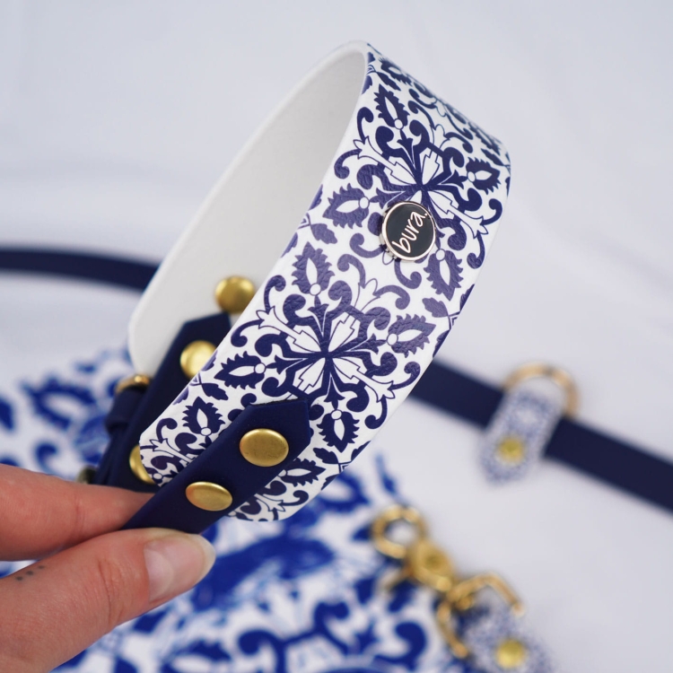 Front szerokiej obroży dla charta z BioThane — wzór azulejo Casa Canina i logo bura na środku.