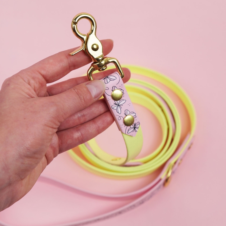 Zbliżenie smyczy miejskiej dla psa Motyle z widocznym karabińczykiem.