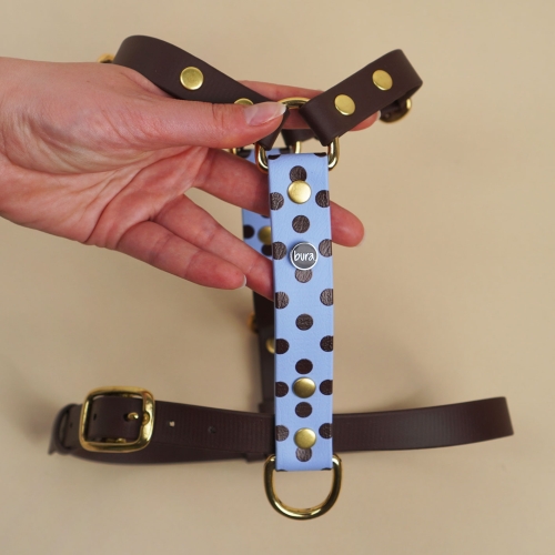 Szelki guard z Biothane dla psa, niebieskie w brązowe kropki, trzymane w dłoni – widok z przodu.
