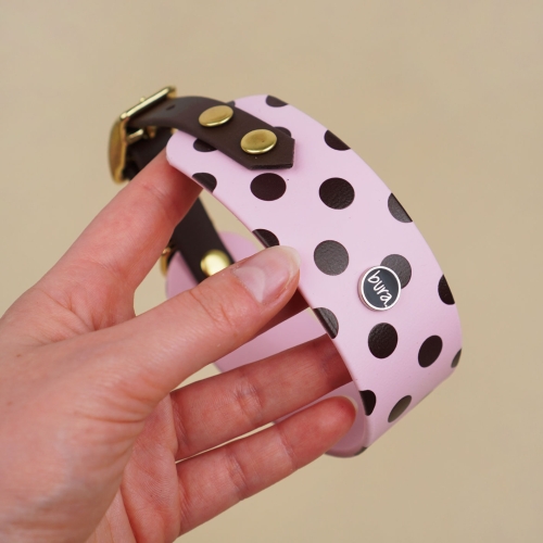 Obroża dla charta z Biothane w brązowe kropki na pudrowym różu, trzymana w dłoni.