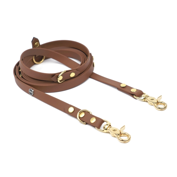 Brązowa smycz multifunkcyjna hands free z Biothane PiesNUT ze złotymi karabińczykami na jasnym tle