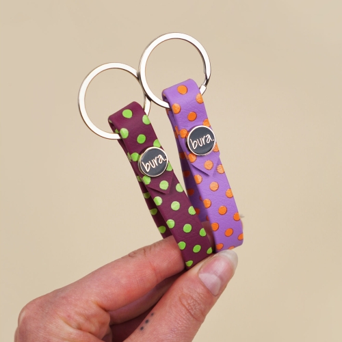 Breloczek do kluczy z biothane w kolorowe kropki – bordo z zielonymi i fiolet z pomarańczowymi grochami, logo Bura, Polka DOGS