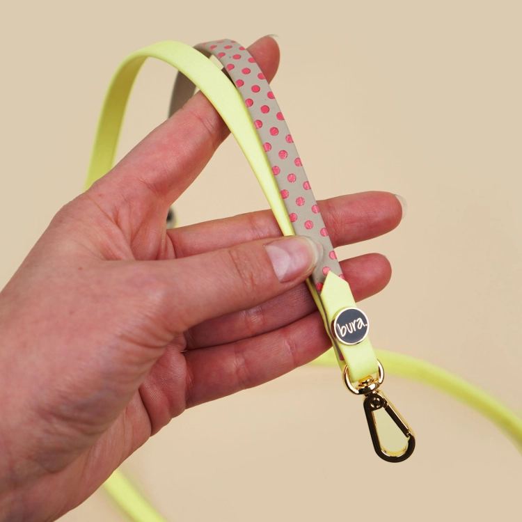 Personalizowana smycz na telefon w kropki z Biothane, hands-free, z regulacją i złotym karabińczykiem – zbliżenie produktu w dłoni